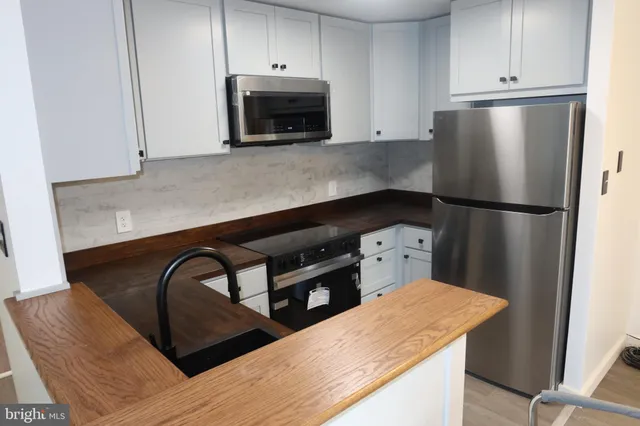 a kitchen with appliances a refrigerator and cabinets