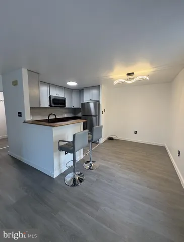 a kitchen with a sink cabinets and wooden floor