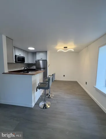 a view of an empty room with wooden floor and windows