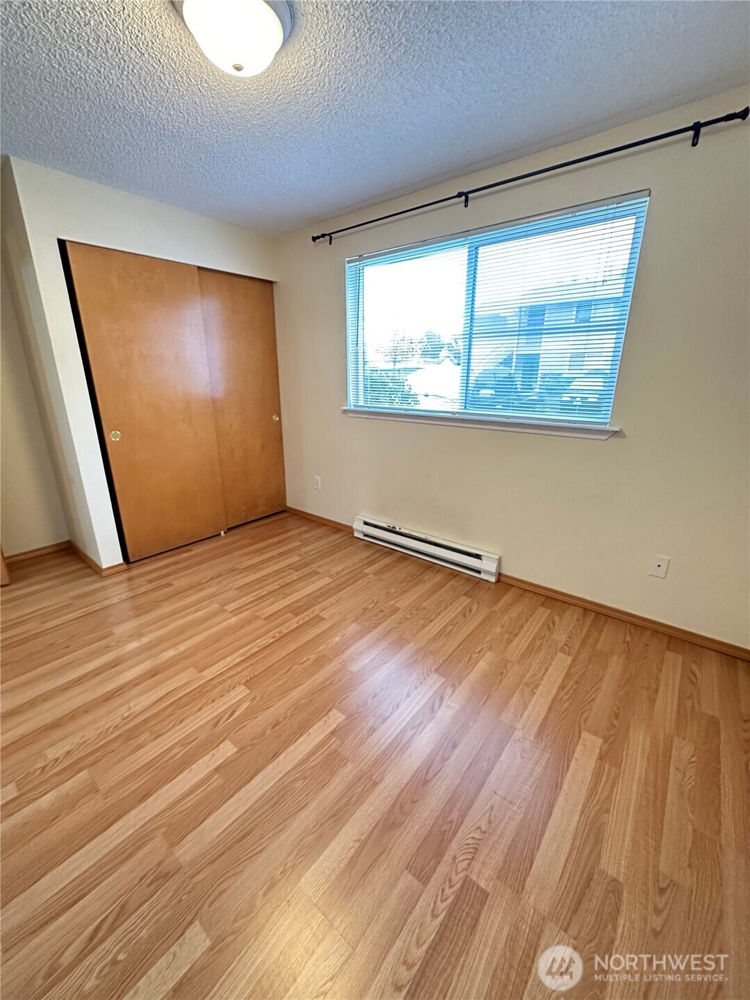 9105 1st Place Northeast, Unit 2 Lake Stevens, WA 98258 - Photo 11 of 13 an empty room with wooden floor and windows
