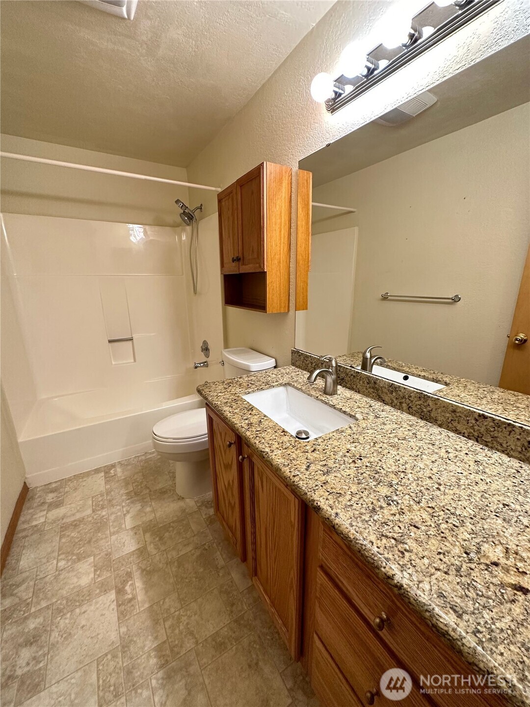 9105 1st Place Northeast, Unit 2 Lake Stevens, WA 98258 - Photo 12 of 13 a bathroom with a granite countertop sink a toilet and shower