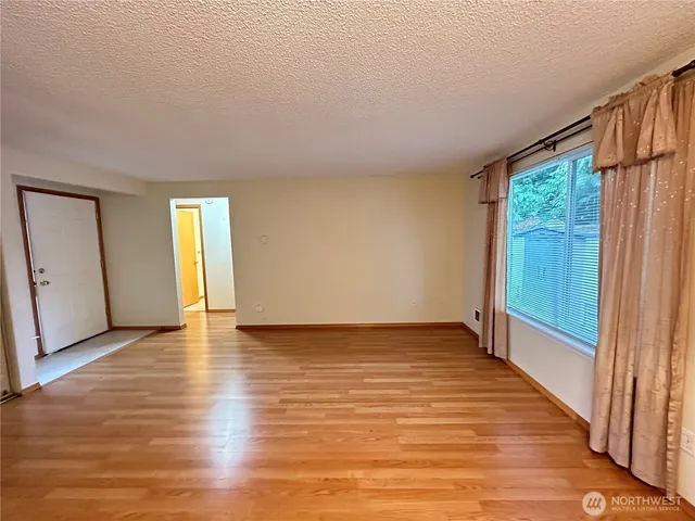 a view of an empty room with glass door and a window