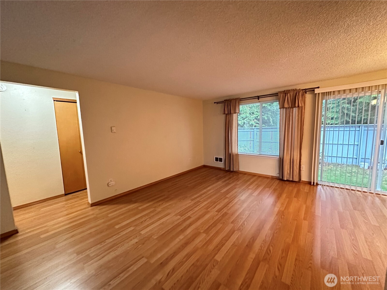 9105 1st Place Northeast, Unit 2 Lake Stevens, WA 98258 - Photo 6 of 13 an empty room with wooden floor and windows