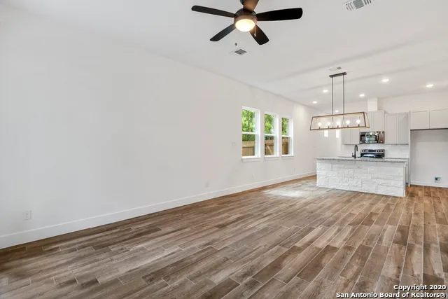 wooden floor in an empty room with a kitchen