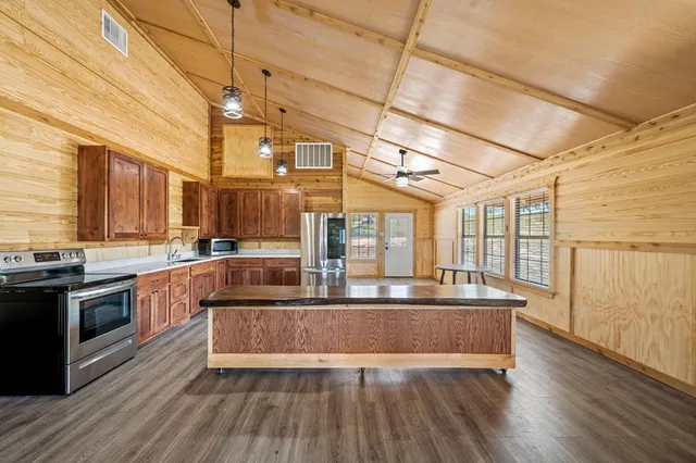 a view of a kitchen with stainless steel appliances granite countertop a stove and a wooden floors