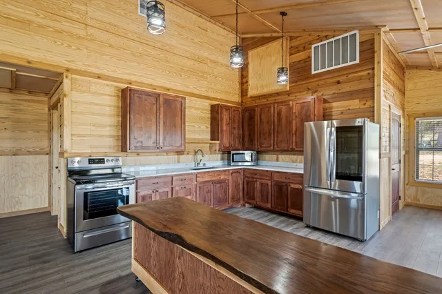 a kitchen with stainless steel appliances granite countertop a stove a sink and a refrigerator