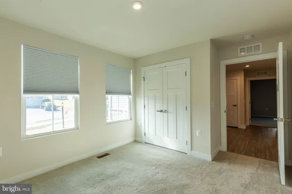 a view of an empty room with window and bathroom