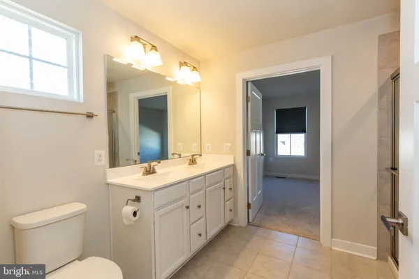 a spacious bathroom with a toilet sink and mirror