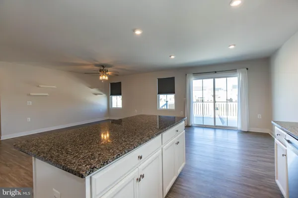 a view of a kitchen island a chandelier and wooden floor