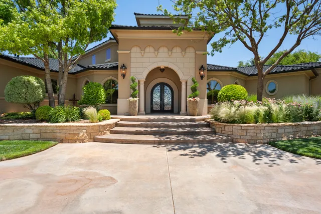 a view of a house with a yard and large tree