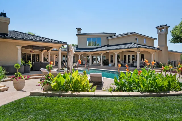 an aerial view of a house with a yard and swimming pool