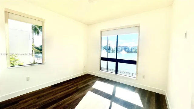 a view of a room with wooden floor and windows