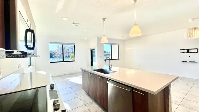 a kitchen with a sink a counter and chairs