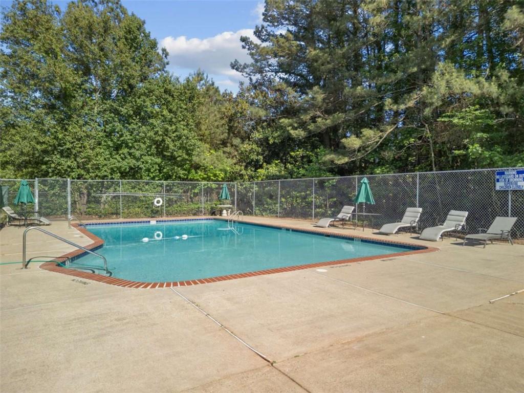 1166 Booth Road, Unit 407 Marietta, GA 30008 - Photo 18 of 18 a view of a swimming pool with a patio