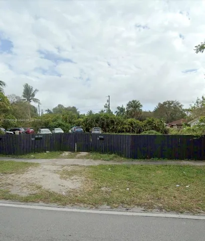 a view of a house with a yard and potted plants