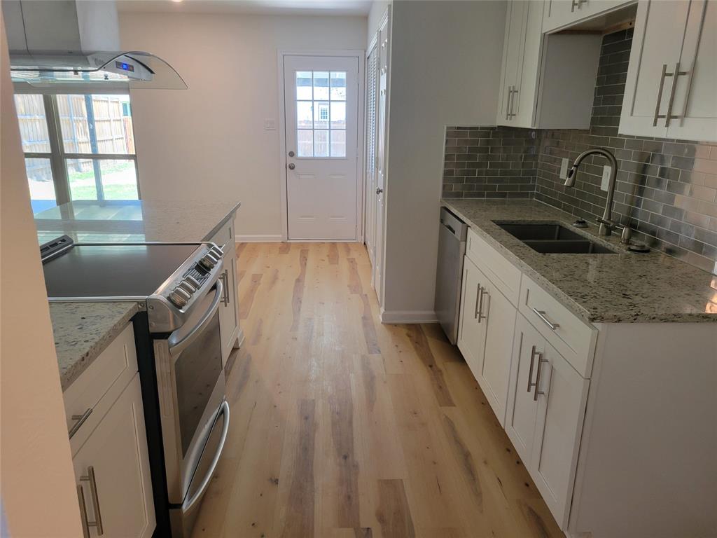 5510 Ridgecove Drive Garland, TX 75043 - Photo 2 of 11 a kitchen with a sink a refrigerator and window