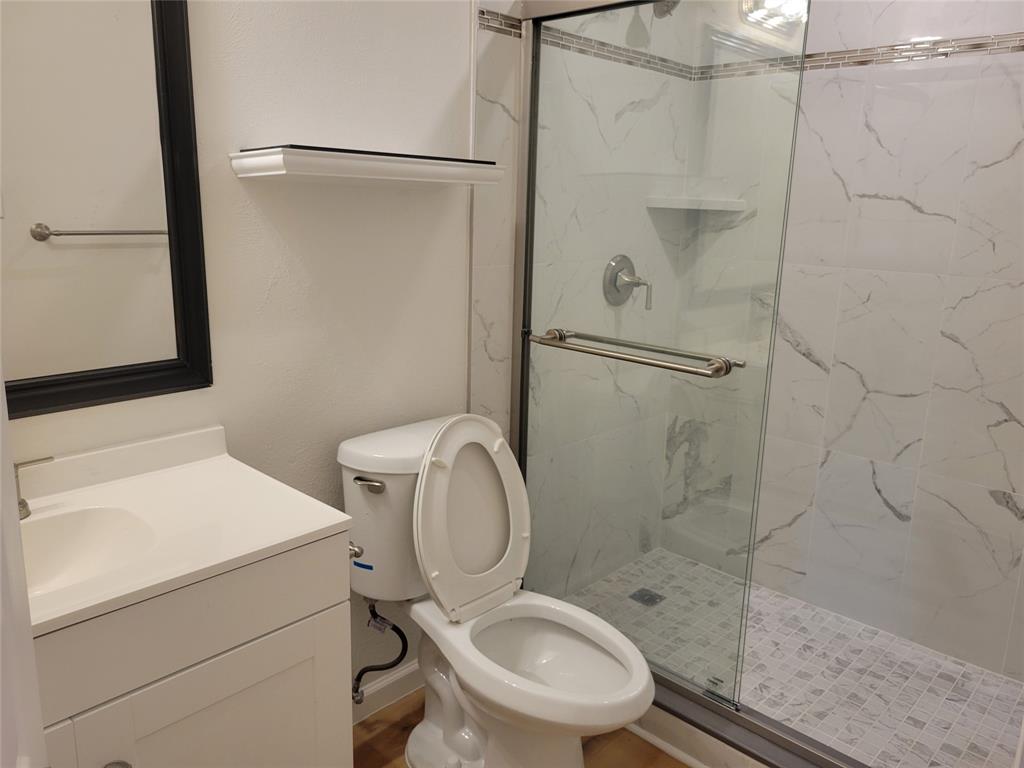 5510 Ridgecove Drive Garland, TX 75043 - Photo 7 of 11 a bathroom with a toilet sink and a shower