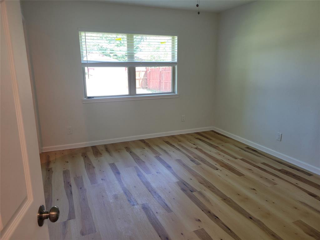 5510 Ridgecove Drive Garland, TX 75043 - Photo 9 of 11 an empty room with wooden floor and windows