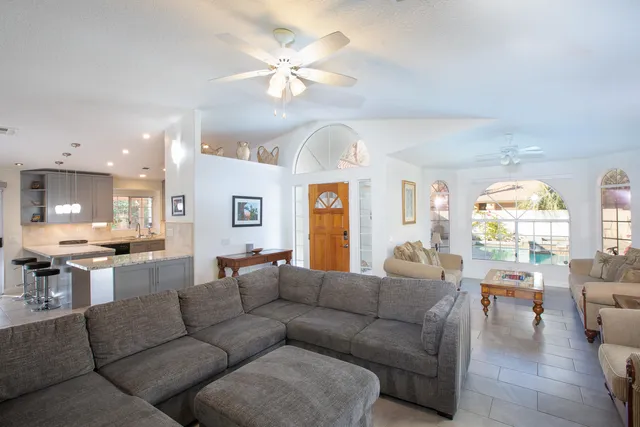 a living room with furniture kitchen and a large window