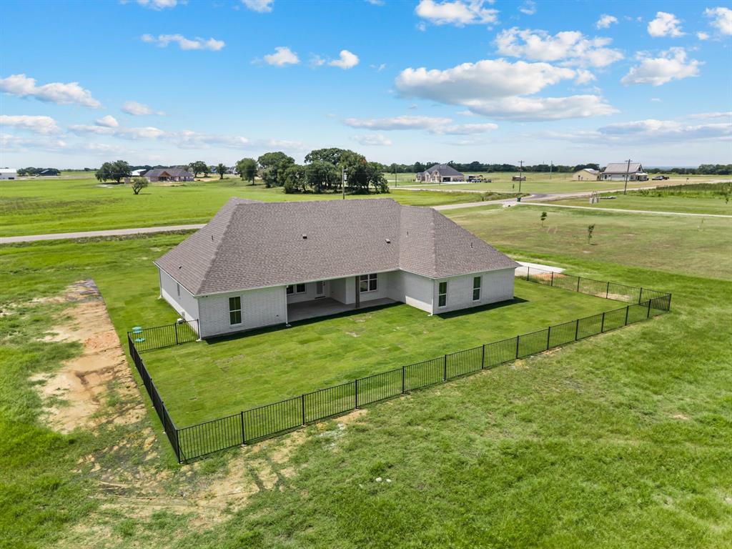 2705 Gospel Road Tolar, TX 76476 - Photo 34 of 36 Expansive rear yard featuring a newly installed black metal fence enclosing a lush green lawn
