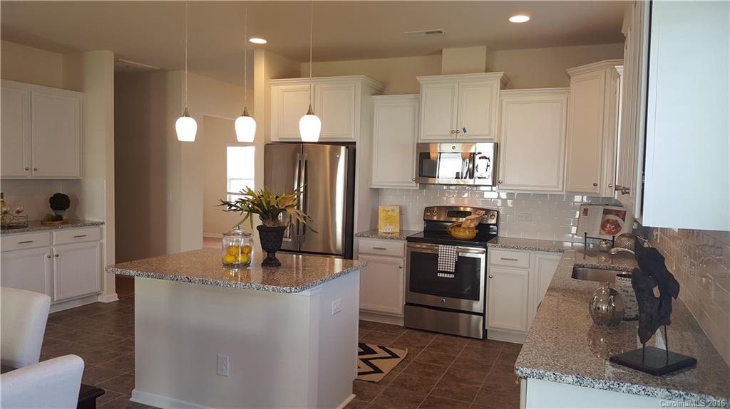 1628 Spring Blossom Trail, Unit SITE 18 Fort Mill, SC 29708 - Photo 10 of 22 a kitchen with stainless steel appliances granite countertop a sink stove and refrigerator