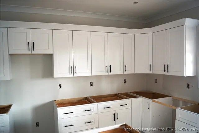 a kitchen with granite countertop white cabinets and sink