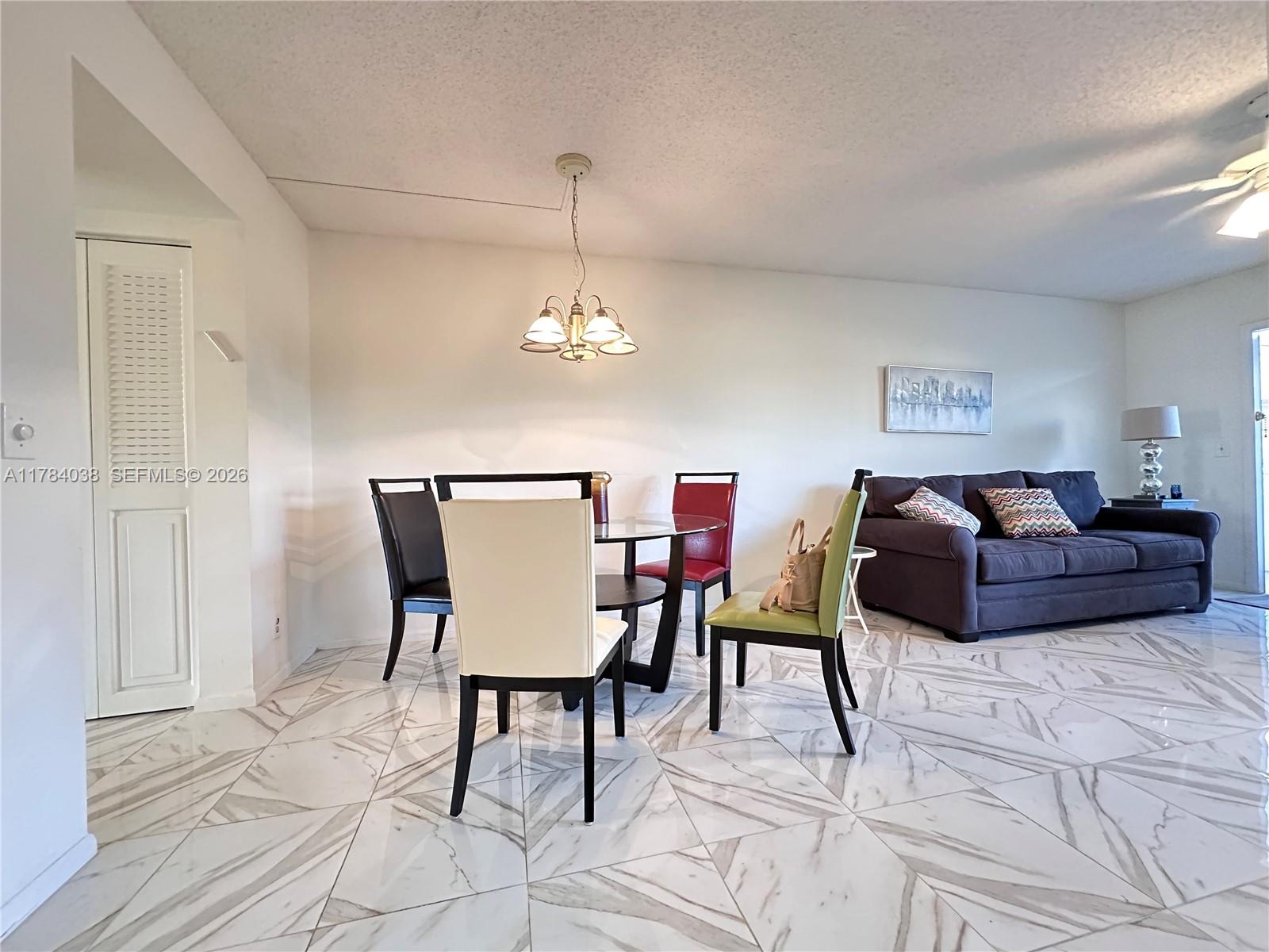 a living room with furniture a dining table and a chandelier