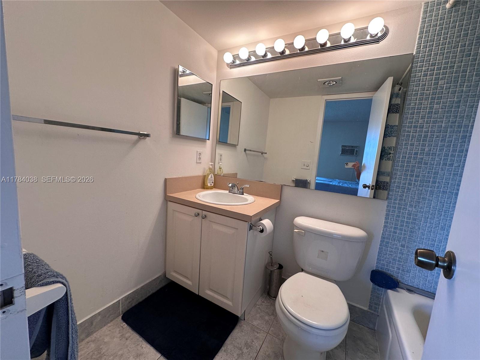 569 Fanshaw North, Unit 569 Boca Raton, FL 33434 - Photo 20 of 22 a bathroom with a toilet a sink and mirror