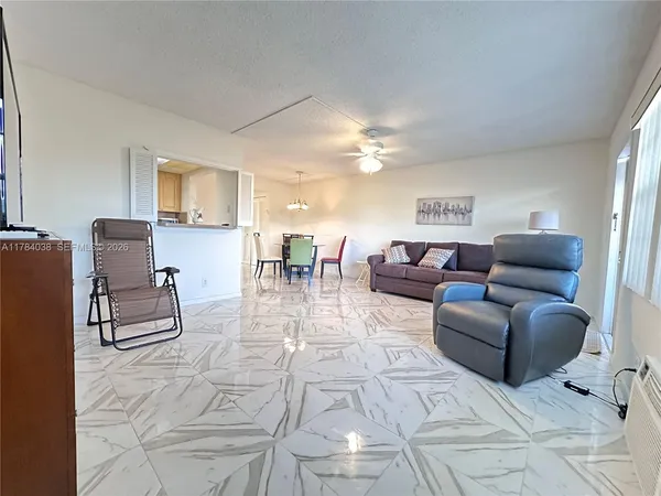 a living room with furniture and a dining table with kitchen view
