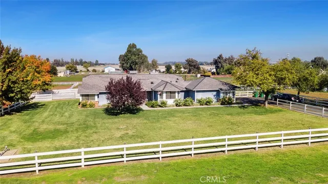 a view of a big house with a big yard and large trees