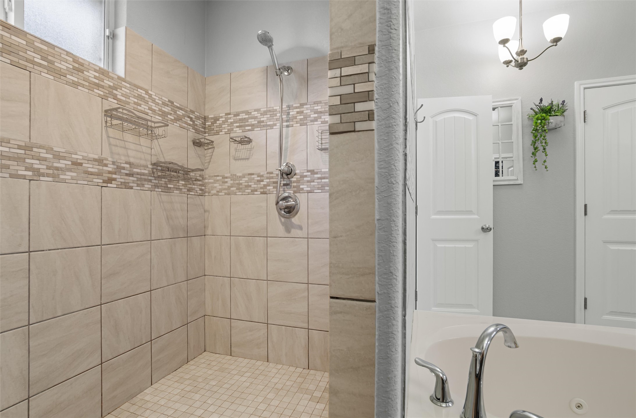 16017 Toby Court Temple, TX 76502 - Photo 17 of 33 Bathroom featuring a tub with jets, a chandelier, and a shower stall