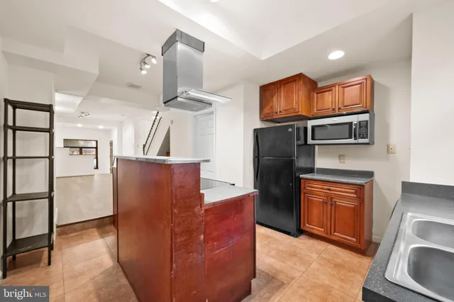 a kitchen with stainless steel appliances granite countertop a refrigerator and a stove top oven