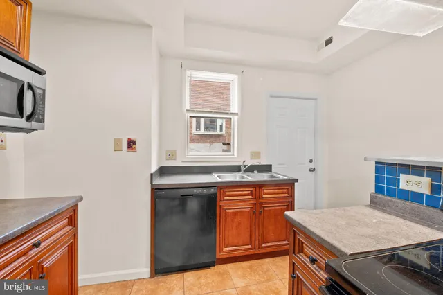 a kitchen that has a sink and a stove in it