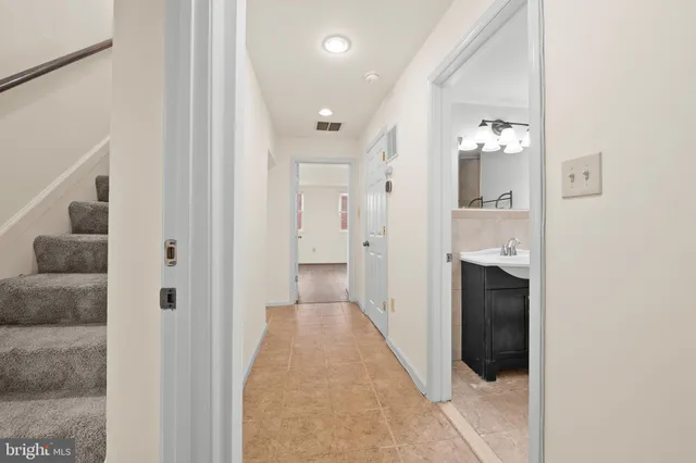 a view of a hallway with wooden floor and staircase