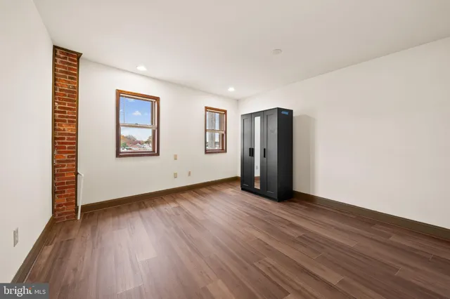 a view of an empty room with closet and a window