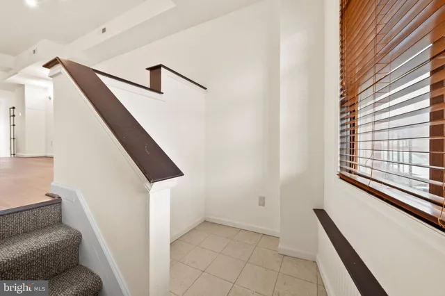 a hallway with stairs and a couch