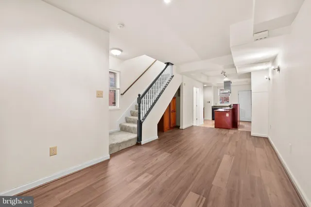 a view of a hallway with wooden floor and staircase