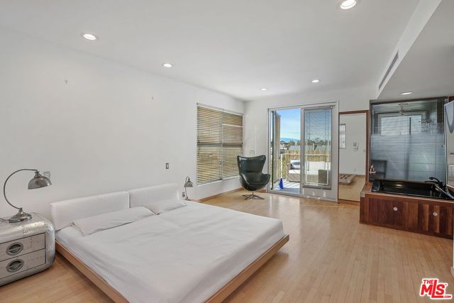 a bedroom with furniture and a large window