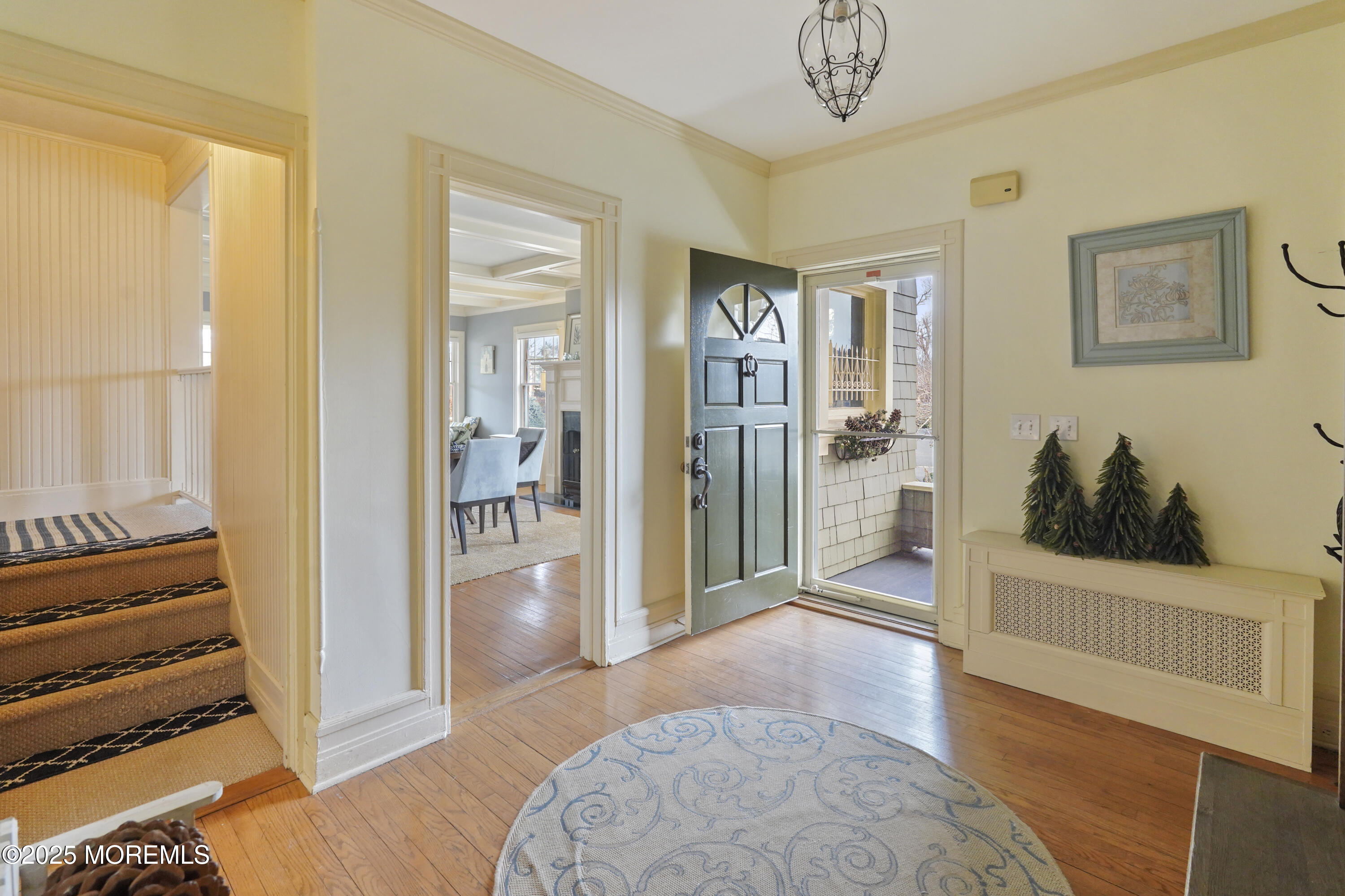 43 Rumson Road Rumson, NJ 07760 - Photo 7 of 28 a view of a hallway to a livingroom with wooden floor and a chandelier