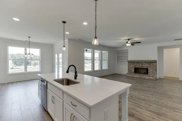 a kitchen with a sink a large window and a fireplace