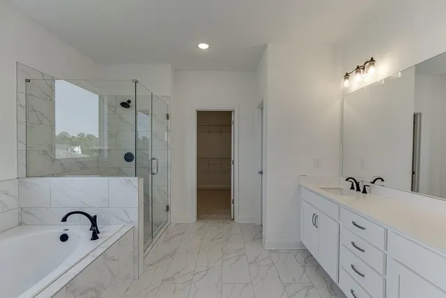 a bathroom with a tub sink double vanity and mirror