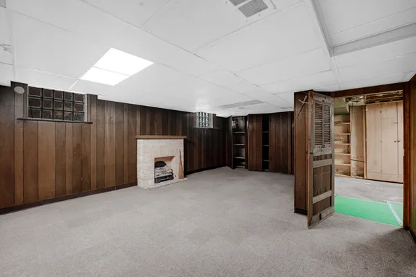 a view of an empty room with furniture and a window
