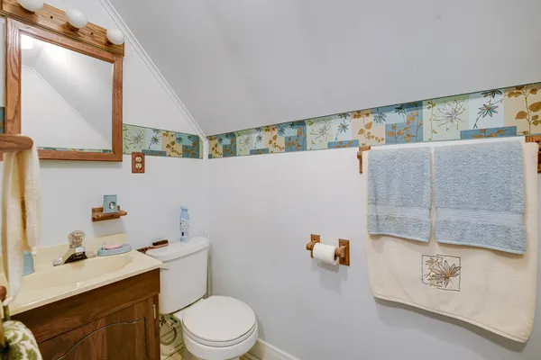 a bathroom with a sink mirror vanity and toilet