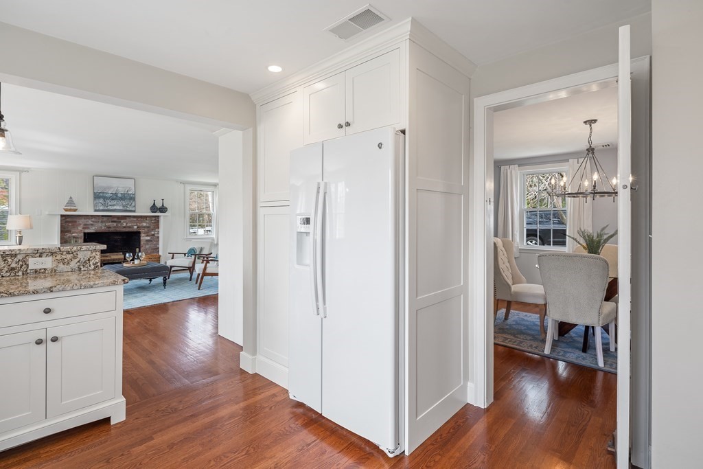 32 Howland Lane Hingham, MA 02043 - Photo 14 of 40 a view of a kitchen and dining room with wooden floor a fireplace