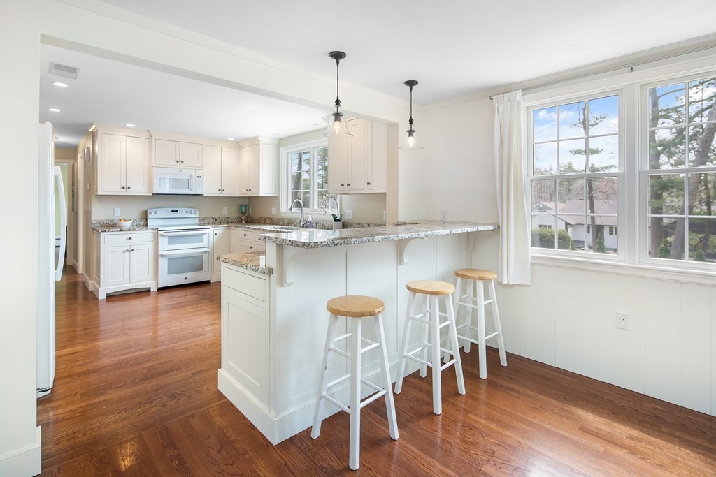 32 Howland Lane Hingham, MA 02043 - Photo 10 of 40 a kitchen with stainless steel appliances granite countertop a stove top oven a refrigerator a island and white cabinets with wooden floor