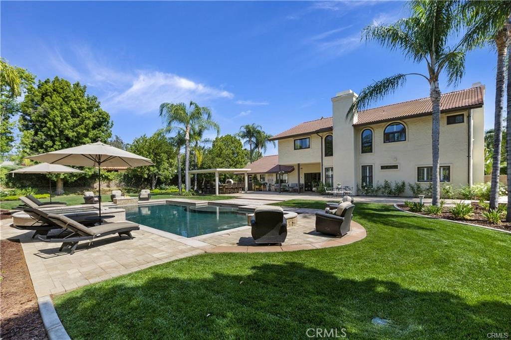 a view of a house with backyard sitting area and swimming pool