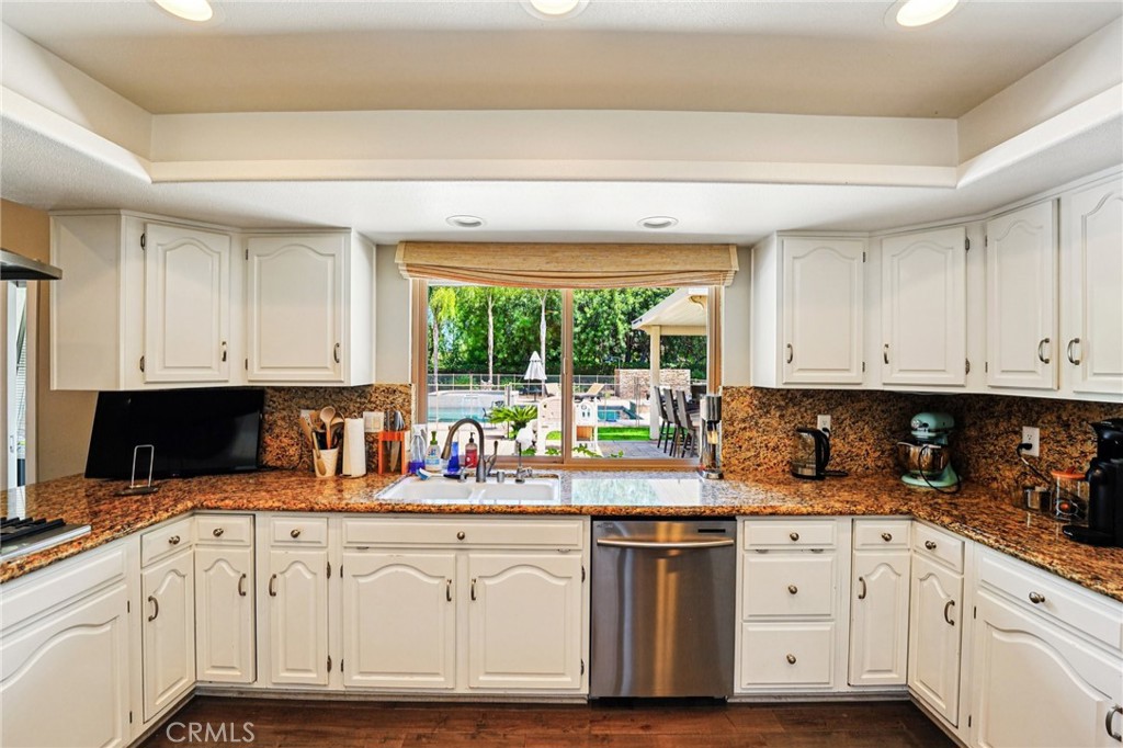 1623 Northhampton Drive Riverside, CA 92506 - Photo 22 of 59 a kitchen with granite countertop white cabinets and white appliances