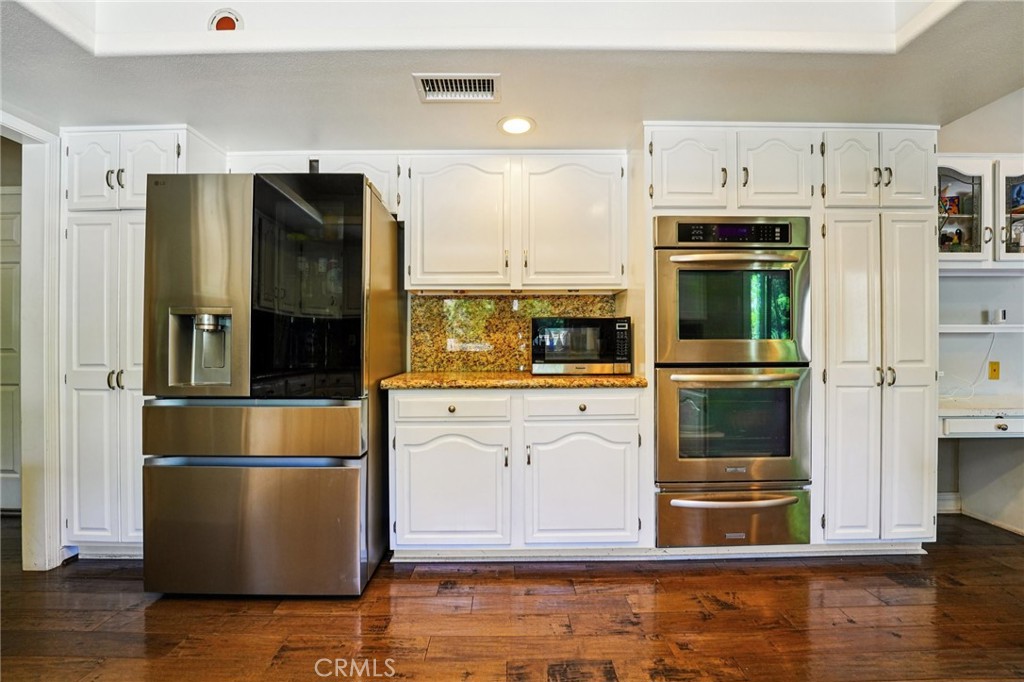 1623 Northhampton Drive Riverside, CA 92506 - Photo 24 of 59 a kitchen with stainless steel appliances and wooden floor