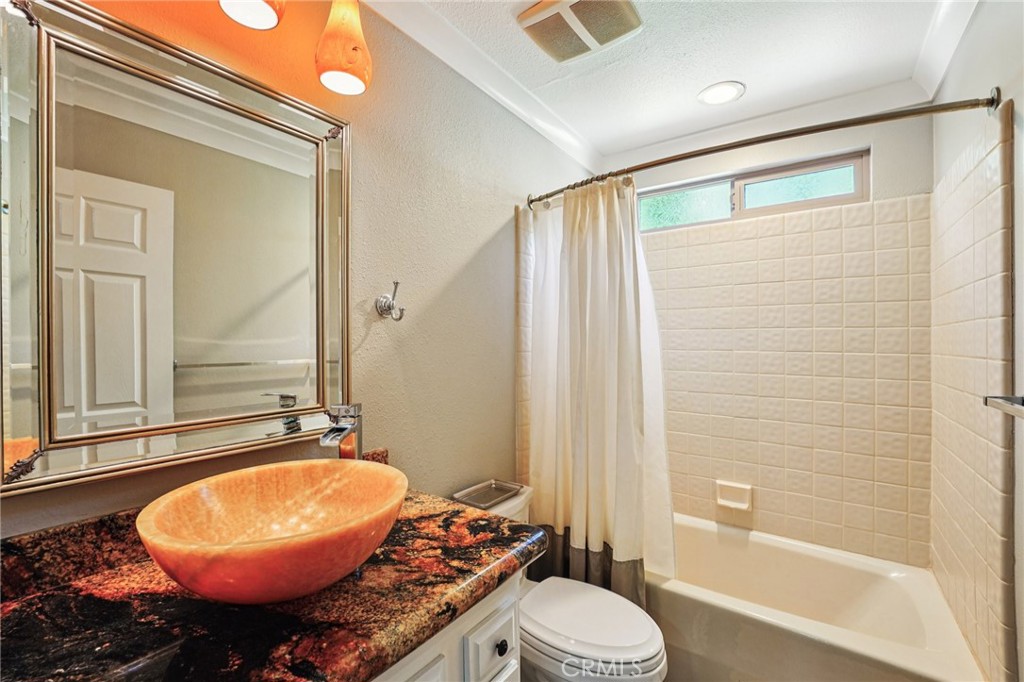 1623 Northhampton Drive Riverside, CA 92506 - Photo 28 of 59 a bathroom with a granite countertop sink toilet a mirror and bathtub