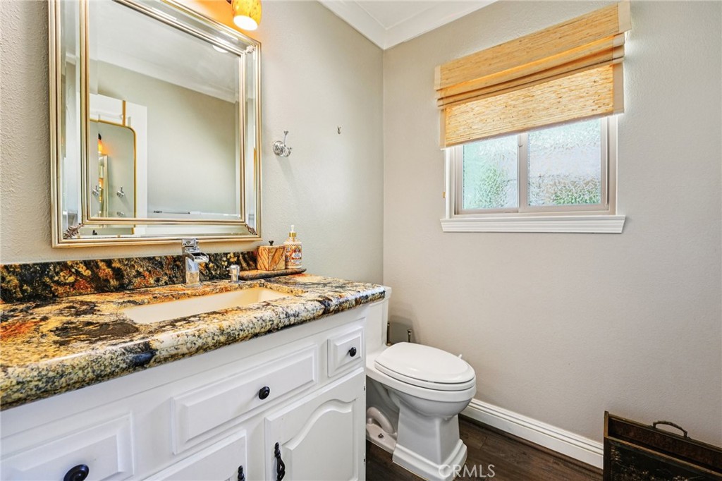 1623 Northhampton Drive Riverside, CA 92506 - Photo 33 of 59 a bathroom with a granite countertop toilet a sink and a mirror
